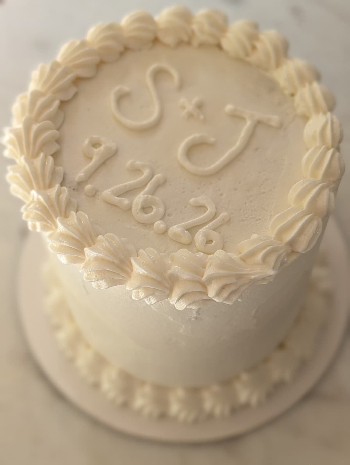 White buttercream mini cake with a piped border from Happy Hippo Bakery in Hutto, Texas