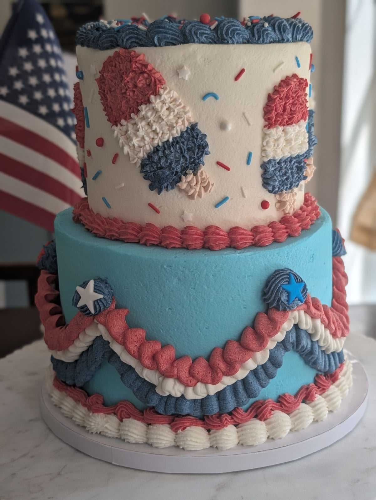 Red, white, and blue two-tier celebration cake by Happy Hippo Bakery in Hutto, Texas