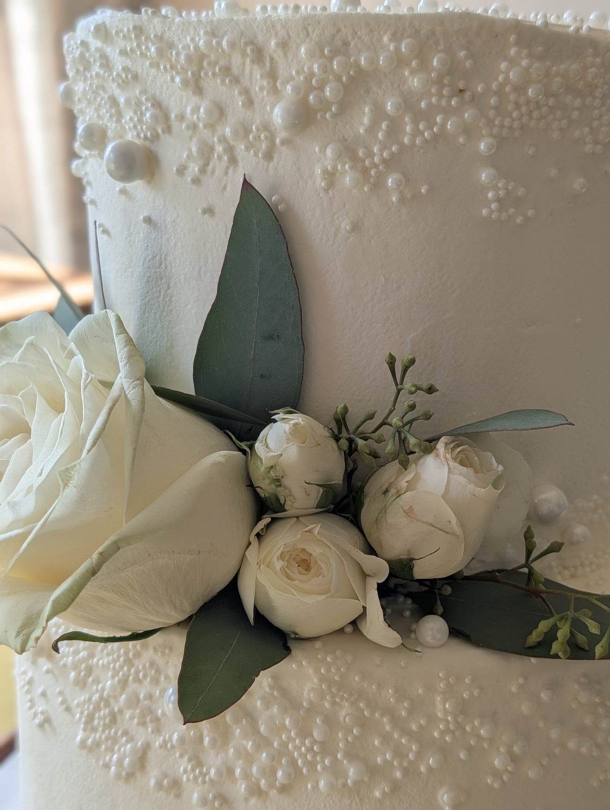 Pearl and fresh-floral detail on a custom wedding cake by Happy Hippo Bakery in Hutto, Texas by Happy Hippo Bakery